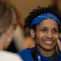 man in blue bandana and blue shirt claps